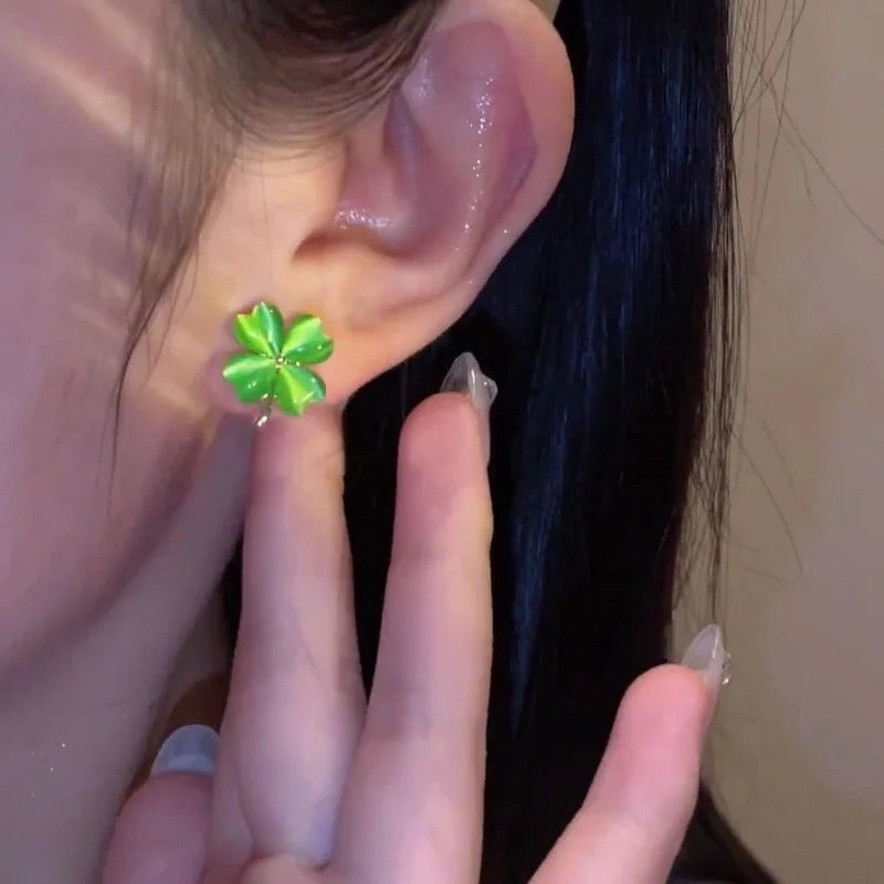 Arete trébol verde jade puesto en la oreja, primer plano